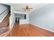 Spacious living room with hardwood floors, ceiling fan, staircase, and light blue walls at 4670 Ernest Dr, Forest Park, GA 30297