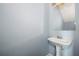 Simple powder room featuring a pedestal sink, mirror, and light blue walls at 4670 Ernest Dr, Forest Park, GA 30297