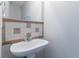Close up of a pedestal sink with decorative tiles and large mirror in a well-lit bathroom at 4915 Truitt Ln, Decatur, GA 30035