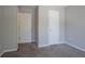 This bedroom features neutral walls, soft carpeting, and white doors, offering a simple space at 4915 Truitt Ln, Decatur, GA 30035