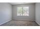 Cozy bedroom featuring neutral walls, soft carpeting, and a bright window overlooking the neighborhood at 4915 Truitt Ln, Decatur, GA 30035