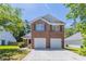 Charming two-story brick home featuring a two-car garage, well-manicured lawn and verdant trees at 4915 Truitt Ln, Decatur, GA 30035