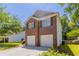 Side view of a brick home with a two-car garage, green lawn and surrounded by lush trees on a sunny day at 4915 Truitt Ln, Decatur, GA 30035