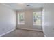 Bedroom features neutral carpet, windows for natural light, and a closet for storage at 1076 Plantation Se Blvd, Conyers, GA 30094