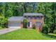 Charming two-story brick home featuring a well-maintained lawn, attached garage, and mature trees at 1076 Plantation Se Blvd, Conyers, GA 30094