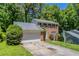 Brick home with an attached garage, mature trees, and a well-maintained front lawn at 1076 Plantation Se Blvd, Conyers, GA 30094