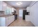 Functional kitchen featuring white cabinets, stainless steel appliances, and neutral tile flooring at 1076 Plantation Se Blvd, Conyers, GA 30094