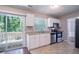 White kitchen features stainless appliances, ample counter space, and deck access at 1076 Plantation Se Blvd, Conyers, GA 30094