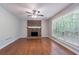 Spacious living room features a brick fireplace, ceiling fan, and lots of natural light at 1076 Plantation Se Blvd, Conyers, GA 30094