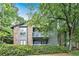 Charming condo exterior with a brick facade and second-story balcony surrounded by mature trees and landscaping at 205 Tuxworth Cir # 205, Decatur, GA 30033