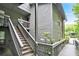 Condo exterior featuring wood siding, stairs leading to the entrance, and lush greenery around the building at 205 Tuxworth Cir # 205, Decatur, GA 30033