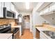 Well-lit kitchen featuring white cabinets, modern appliances, and a view into the laundry area at 205 Tuxworth Cir # 205, Decatur, GA 30033