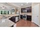 Open concept kitchen features granite countertops, stainless steel appliances, and dark cabinets at 4625 Cold Spring Court, Cumming, GA 30041