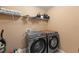 Laundry room with side-by-side washer and dryer, utility shelf and cleaning accessories at 4625 Cold Spring Court, Cumming, GA 30041