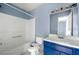 Cozy bathroom featuring a tub-shower combo, toilet, and stylish blue vanity with white countertop at 2465 Brianna Dr, Hampton, GA 30228
