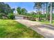 View of home from driveway with a well-manicured lawn, tall trees, and attached garage at 4590 Sims Ct, Tucker, GA 30084