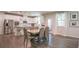 Open-concept dining area adjacent to a modern kitchen, featuring hardwood floors and lots of natural light at 688 Saffron Blvd, Lawrenceville, GA 30045