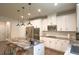 Bright, open kitchen with white cabinets, stainless steel appliances, and a large island with marble countertops at 688 Saffron Blvd, Lawrenceville, GA 30045