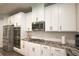 Bright white kitchen featuring stainless steel appliances and granite countertops at 688 Saffron Blvd, Lawrenceville, GA 30045