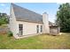 Side and rear exterior of one-story beige house with a gray roof and enclosed backyard at 7270 Williamsburg Dr, Riverdale, GA 30274