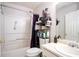 Functional bathroom with a shower-tub combo, featuring an array of toiletries and a clean vanity area at 7270 Williamsburg Dr, Riverdale, GA 30274