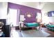 Cozy bedroom with a colorful accent wall, featuring a large bed, a ceiling fan, and a mounted TV at 7270 Williamsburg Dr, Riverdale, GA 30274