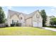 Charming two-story home featuring a two-car garage and a well-maintained front lawn on a clear, sunny day at 7270 Williamsburg Dr, Riverdale, GA 30274