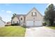 Charming two-story home featuring a two-car garage and a well-maintained front lawn on a clear, sunny day at 7270 Williamsburg Dr, Riverdale, GA 30274