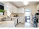 A kitchen featuring white cabinetry, stainless steel appliances, and a view into the adjacent living area at 7270 Williamsburg Dr, Riverdale, GA 30274