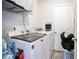 Functional laundry room featuring a washer, dryer, storage shelf, and a door to the outside at 7270 Williamsburg Dr, Riverdale, GA 30274