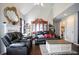 Bright living room featuring a vaulted ceiling, a decorative fireplace, hardwood floors, and comfortable leather seating at 7270 Williamsburg Dr, Riverdale, GA 30274