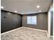 Neutral bedroom with gray wood-look vinyl flooring, modern lighting, and a large window at 3079 Colonial Way # J, Atlanta, GA 30341