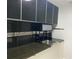 Modern kitchen design with stainless steel sink, dark granite countertops, and black backsplash at 3079 Colonial Way # J, Atlanta, GA 30341