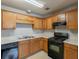 This kitchen features oak cabinets, a black gas range, a black dishwasher, and a double-basin sink at 3531 Brookstone Way, Union City, GA 30291