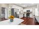 Modern kitchen with stainless steel appliances, white cabinets, and hardwood floors, next to a breakfast area at 5010 Foxberry Ln, Roswell, GA 30075
