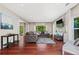 Bright living room with hardwood floors, a stone accent wall, and large windows overlooking the backyard at 5010 Foxberry Ln, Roswell, GA 30075