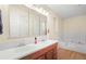 Well-lit bathroom featuring a double vanity, large mirror, and a bathtub for relaxing soaks at 142 Old Hampton Way, Hampton, GA 30228