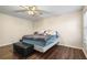 Comfortable main bedroom featuring hardwood floors, a ceiling fan, neutral colors, and natural lighting at 142 Old Hampton Way, Hampton, GA 30228
