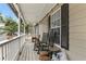 Relaxing porch featuring rocking chairs, string lights, and a view of the surrounding trees at 142 Old Hampton Way, Hampton, GA 30228