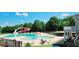 Resort-style community pool with a waterslide, splash fountain, ample lounge seating, and lush surroundings at 205 Kestrel Cir, Covington, GA 30014