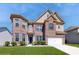 Charming two-story brick home featuring manicured landscaping, a two-car garage, and a welcoming front entrance at 205 Kestrel Cir, Covington, GA 30014
