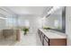 A neutral bathroom features marble flooring, a glass shower, and double vanities with granite countertops at 205 Kestrel Cir, Covington, GA 30014