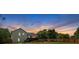 Scenic backyard view at sunset featuring lush greenery, a wooden fence, and a charming deck for relaxing and entertaining at 21 Collins Dr, Douglasville, GA 30134