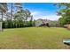 Expansive backyard featuring a large grassy area, mature trees, and a charming deck, ideal for outdoor recreation at 21 Collins Dr, Douglasville, GA 30134