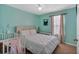 Brightly painted bedroom contains a queen-sized bed, crib, and guitar, with natural light from window at 21 Collins Dr, Douglasville, GA 30134