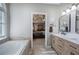 Bathroom with double vanity and soaking tub with an open doorway to main bedroom in background at 3186 Sail Winds Nw Dr, Acworth, GA 30101