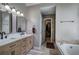 Well-lit bathroom featuring a double vanity, soaking tub, and doorway to a walk-in closet at 3186 Sail Winds Nw Dr, Acworth, GA 30101