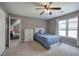 Carpeted bedroom featuring a ceiling fan, and a large window with curtains, offering a bright and airy space at 3186 Sail Winds Nw Dr, Acworth, GA 30101
