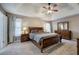 Bedroom with a tray ceiling, lots of natural light, carpet, and wood furniture at 3186 Sail Winds Nw Dr, Acworth, GA 30101