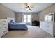 Cozy bedroom featuring a ceiling fan, neutral color palette, carpet and large windows, creating a relaxing atmosphere at 3186 Sail Winds Nw Dr, Acworth, GA 30101